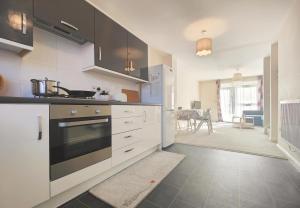 a kitchen with white cabinets and a stove top oven at The Bushmoor - Spacious Holiday Townhouse 10 Minutes to City Centre Free Parking in Manchester