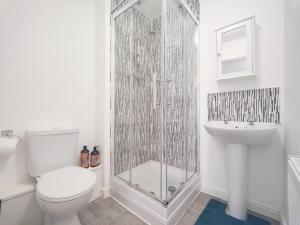 a bathroom with a shower and a toilet and a sink at The Bushmoor - Spacious Holiday Townhouse 10 Minutes to City Centre Free Parking in Manchester