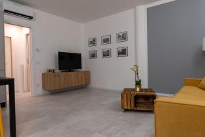 sala de estar con TV y sofá en La casa sul Naviglio, en Milán