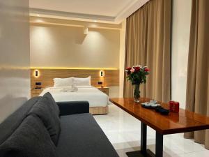 orientalhotel东方酒店 في الدار البيضاء: غرفه فندقيه بسرير واريكه وطاولة