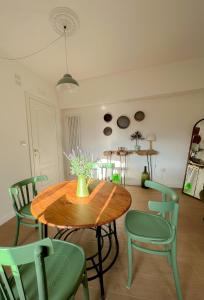 ein Esszimmer mit einem Holztisch und grünen Stühlen in der Unterkunft Palazzo Donnamaria in Manfredonia