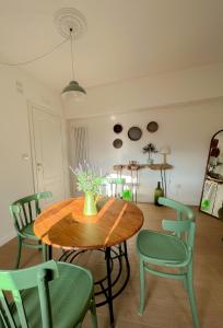 a dining room with a wooden table and green chairs at Palazzo Donnamaria in Manfredonia
