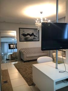 sala de estar con TV y sofá en Paracatu Plaza Hotel, en Paracatu