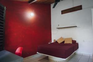 Brisas de ZicatelaにあるPacific Buddhaの赤い壁のベッドルーム1室(ベッド1台付)