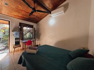 a bedroom with a green bed and a desk at Pacific Buddha in Brisas de Zicatela