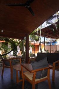 a patio with chairs and a couch and a table at Pacific Buddha in Brisas de Zicatela