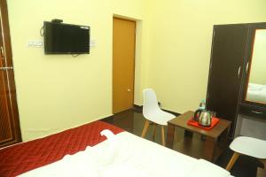 una camera con letto e TV a parete di Hotel Misty Haven Retreat a Yercaud