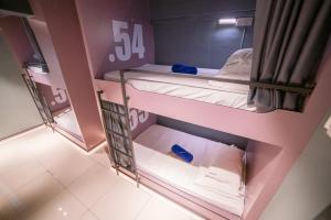 two bunk beds in a room with pink walls at Homy Seafront Hostel in Kota Kinabalu