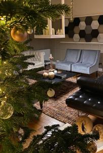 a living room with a christmas tree and a couch at L’orée du bois des rois in Ury