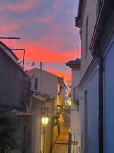an alley with buildings and a sunset in the background at Casa Pilar in Lanciano