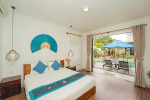 a bedroom with a bed and a pool at Seagull Nest Hoi An Beach Village in Tân Thành (1)