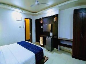 una camera da letto con un letto e una TV a schermo piatto di Collection O Ziva Resort Near Calangute Beach a Calangute