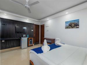 una camera da letto con un letto e una TV a schermo piatto di Collection O Ziva Resort Near Calangute Beach a Calangute