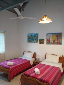 a bedroom with two beds and a ceiling fan at Turquoise in Blue Bay