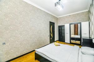 1 dormitorio con cama blanca y sofá blanco en Apartment Armani Lux en Bakú