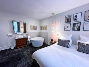 een hotelkamer met een bed en een bad bij Moulin de Fourges in Fourges