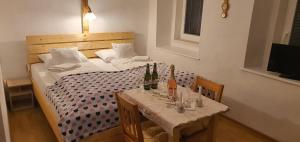 a bed with a table with bottles of wine on it at CARPE DIEM in Ryžoviště