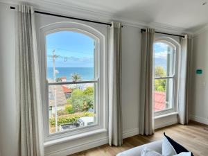 uma sala de estar com duas janelas grandes e o oceano em St James - Villa Mosselle em St James