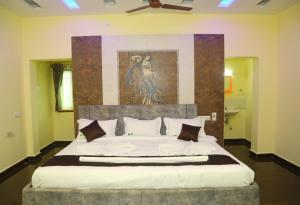 una camera da letto con un grande letto e un dipinto sul muro di Hotel Misty Haven Retreat a Yercaud