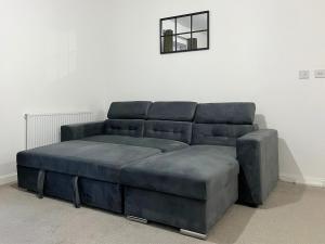 a blue couch sitting in a living room at Stylish 1 Bedroom Apartment with Sofa Bed - Opposite Racecourse, Near City Centre and Hospital in Doncaster