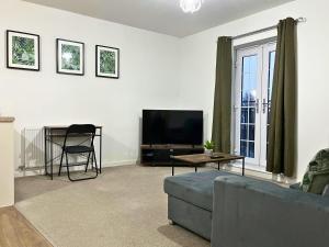 a living room with a couch and a tv at Stylish 1 Bedroom Apartment with Sofa Bed - Opposite Racecourse, Near City Centre and Hospital in Doncaster