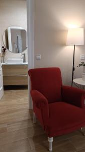 sala de estar con silla roja y lavamanos en Ciudad del Encaje 1, en Almagro
