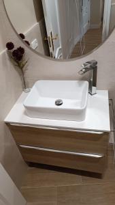 lavabo blanco en el baño con espejo en Ciudad del Encaje 1, en Almagro