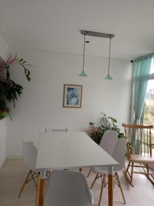 a white dining room with a white table and chairs at los troncos 2 in Puerto Madryn