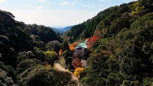 a mountain valley with a house in the middle at Kirishima Seiryuso in Kirishima
