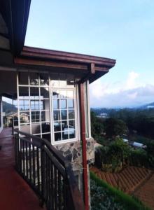 a balcony of a house with a view of the mountains at King's Lodge in Nuwara Eliya