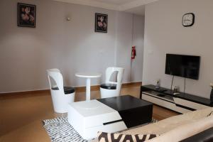 a living room with a black table and white chairs at IMMOBILIER ABBAS in Yaoundé