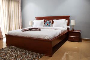 a bedroom with a large bed with white sheets at IMMOBILIER ABBAS in Yaoundé