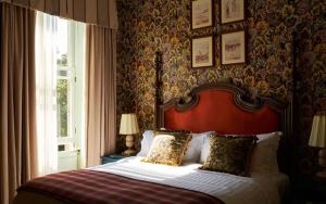 a bedroom with a bed with a red headboard and a window at Marine North Berwick in North Berwick