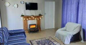 a living room with a couch and a fire place at Lynthorn Farm Cottage in Frere