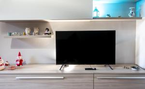 a flat screen tv sitting on top of a entertainment center at Etna Sunshine Apartments in Linguaglossa