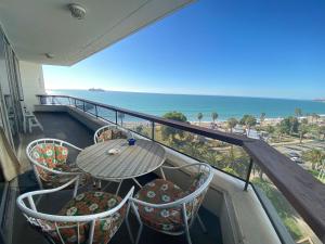 balcón con mesa, sillas y vistas al océano en Departamento excelente ubicación frente a playa, en Viña del Mar