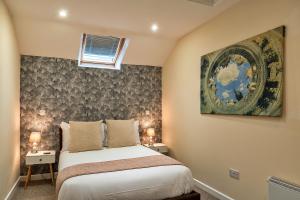 Finest Retreats - The Lodge at The Cridford Inn في Trusham: غرفة نوم بسرير ودهان على الحائط