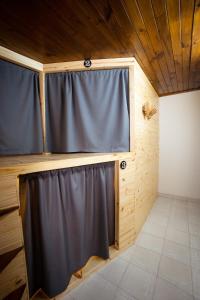 a room with a black curtain in a wooden house at LEAD Pods Hostel in Salta