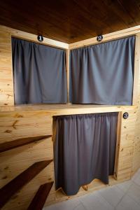 a room with gray curtains on a wooden wall at LEAD Pods Hostel in Salta