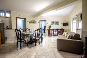 a living room with a table and chairs and a couch at Etna Sunshine Apartments in Linguaglossa