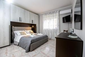 a bedroom with a bed and a desk and a television at Etna Sunshine Apartments in Linguaglossa