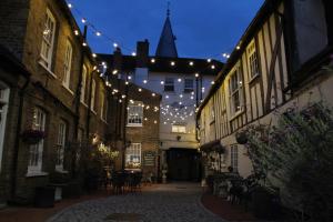 a string of lights hanging over an alley with buildings at Blue Boar Hotel in Maldon
