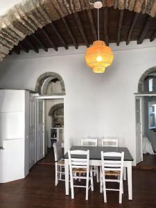 a dining room with a table and chairs and a chandelier at La maison, Triandaros in Triandáros
