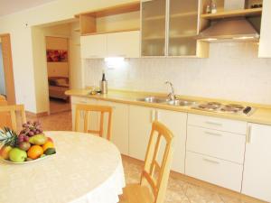 una cocina con una mesa con un bol de fruta. en Apartments Luna, en Tisno