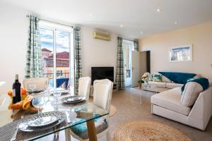uma sala de estar com uma mesa de vidro e um sofá em LE PROVENCAL AP4389 By Riviera Holiday Homes em Villefranche-sur-Mer