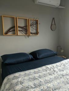 um quarto com uma cama com almofadas azuis em Cantinho Estilo em Santa Maria