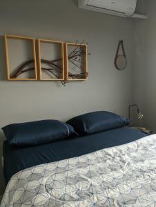 una camera da letto con un letto con cuscini blu di Cantinho Estilo a Santa Maria