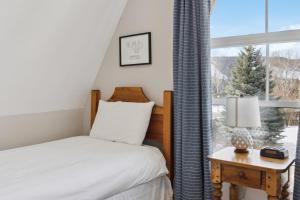- une chambre avec un lit et une fenêtre dans l'établissement 3BR Snowbridge Chalet in Blue with Golf Course View, à Collingwood