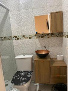 uma casa de banho com um WC e um lavatório em pousada fast sleep no Guarujá