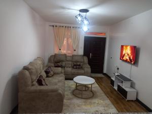 uma sala de estar com um sofá e uma mesa em THE G2 em Nakuru